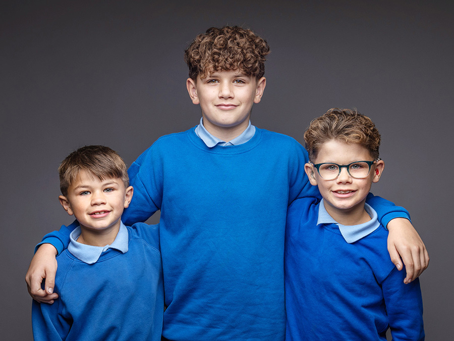 Three pupils in blue school uniform photographed by Keystage Photography