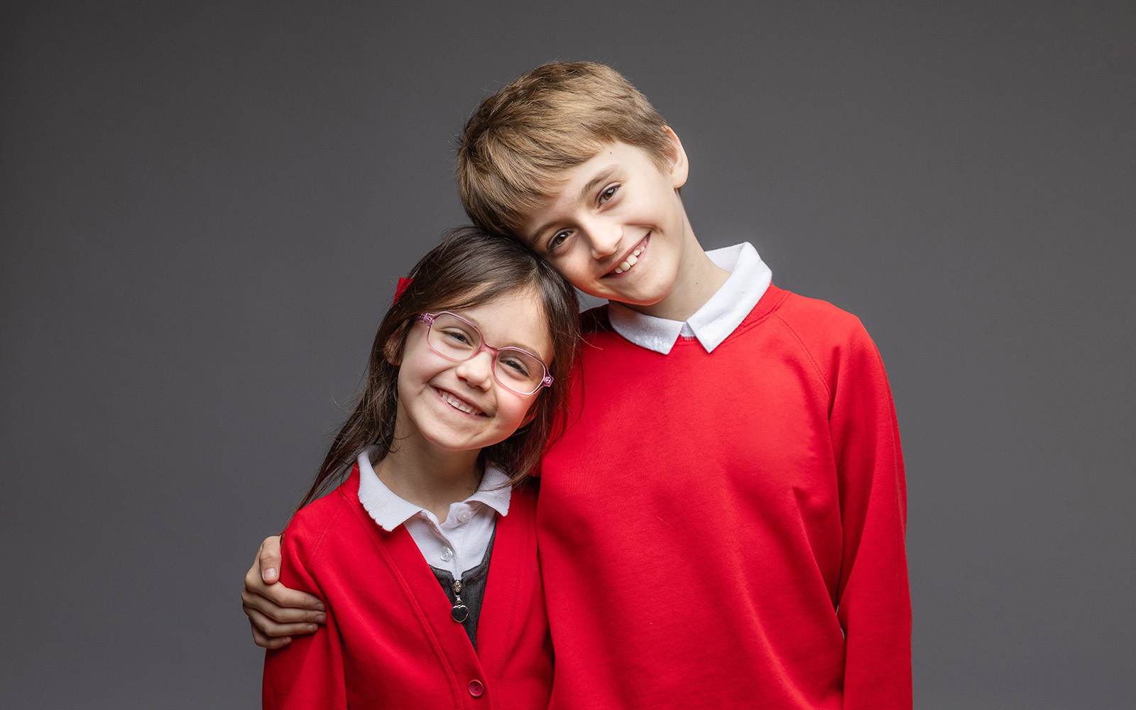 Two siblings in red school uniform — school portrait photography by Keystage